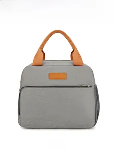 Front view of grey insulated lunch bag with orange handles and convenient mesh side pocket