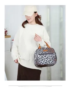 Lifestyle shot of an insulated leopard print lunch tote bag with durable handles