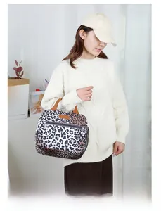 Close-up of leopard print lunch bag with zipper, mesh pocket, and brown strap