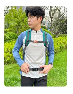 Detail of outdoor backpack chest strap with orange emergency whistle and waist buckle system