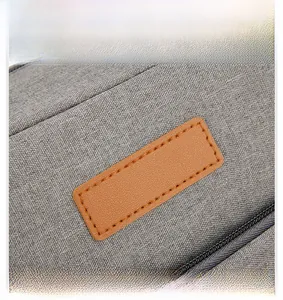 Detail shot of the waterproof grey fabric and brown leather patch on the lunch bag