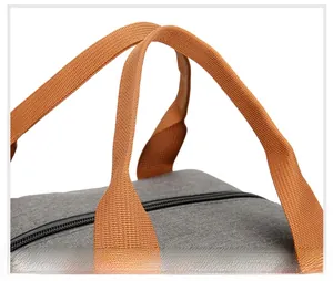 Close-up of durable gray Oxford fabric lunch bag with reinforced orange carry handles