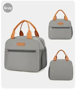 Detail view of grey oxford fabric lunch bag with orange handles and mesh side pocket