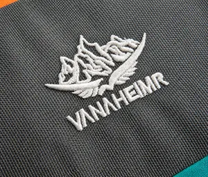 Detailed close-up of the waterproof fabric and white embroidery logo on the gray hiking pack