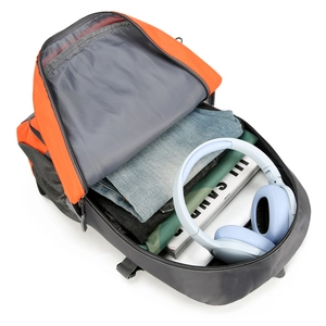 Large orange hiking backpack showing spacious main compartment with clothes and gear