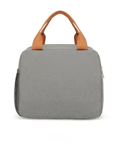 Detail view of the durable grey Oxford cloth lunch bag featuring bright orange handles