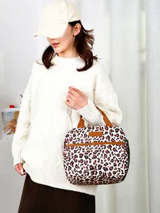 Detail view of leopard print insulated lunch bag with zipper pocket and mesh side