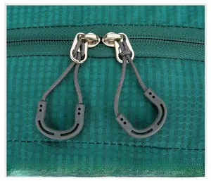 Close-up of green honeycomb ripstop fabric and ergonomic U-shaped dual zipper pulls