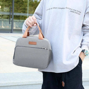 Grey waterproof oxford fabric lunch bag with brown handles and insulated interior