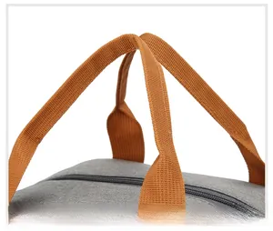 Detail of grey Oxford cloth lunch bag featuring durable orange-brown handles and metal zipper