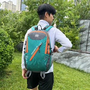 Sac à dos de randonnée 40L vert et orange porté par un homme en plein air