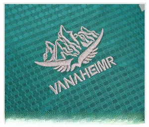 Detailed teal honeycomb fabric with VANAHEIMR mountain embroidery for outdoor hiking backpacks