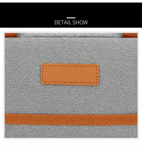 Macro detail of grey oxford fabric texture with brown leather label and orange strap edge