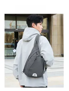 Detail of grey Oxford fabric crossbody bag with reflective strip on urban model