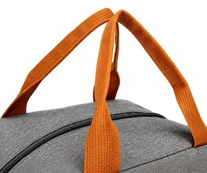 Detail of the gray Oxford fabric lunch bag showing reinforced orange woven handles and zipper