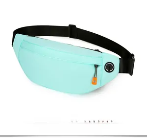 Detail of mint green waterproof running waist bag with headphone port and orange zipper pull