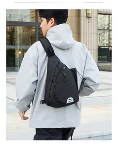 Detail of waterproof nylon crossbody chest bag featuring side mesh pocket and reflective logo