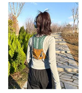 Outdoor hydration vest with green mesh and brown nylon pockets shown in use on trail