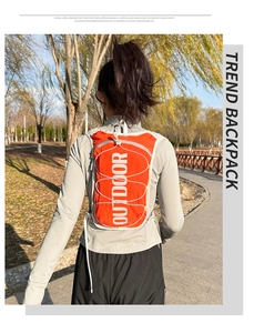 Macro detail of high-visibility orange running vest featuring vertical Outdoor lettering