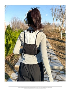 Detail view of the black breathable running vest back with OUTDOOR print and zipper pocket