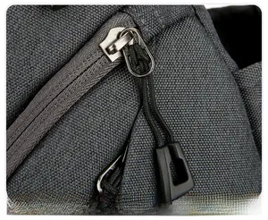Detail of durable grey oxford fabric with smooth silver metal zipper and black pull cord
