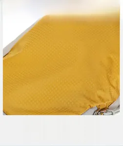 Close-up of yellow ripstop fabric with tear-resistant grid pattern and water-repellent finish