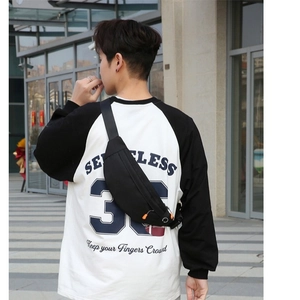 Waterproof black nylon sports waist bag with adjustable strap worn by person in outdoor setting