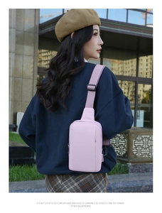 Pink waterproof crossbody chest bag with adjustable strap worn by a woman on city street