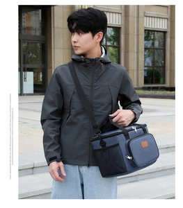 Bolsa térmica azul con correa ajustable mostrada por un modelo en un entorno al aire libre