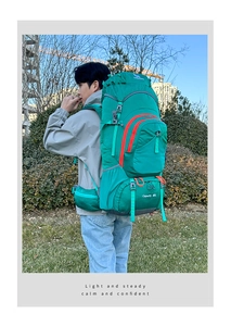 Close-up of 80L emerald green hiking backpack with orange zippers on hiker side view
