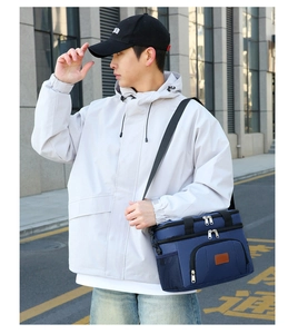 Deep blue multi-functional insulated lunch bag worn over the shoulder on a city street