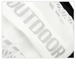 Macro shot of breathable fabric with silver reflective Outdoor logo and geometric pattern