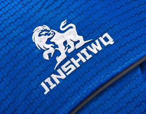 Close-up of durable blue woven fabric with white embroidered logo on outdoor hiking backpack