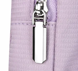 Detalle de la cremallera de metal plateado y tela de nailon púrpura de la bolsa bandolera