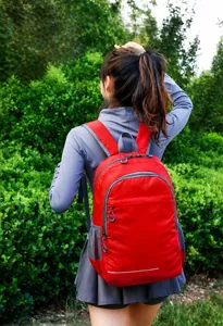 Close-up of red lightweight foldable outdoor backpack with water-resistant nylon texture