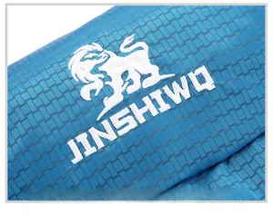Detailed close-up of white logo embroidery on durable blue grid fabric for 80L hiking backpack