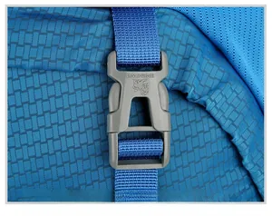 Close-up of blue 80L hiking backpack featuring a durable grey lion logo buckle and grid fabric