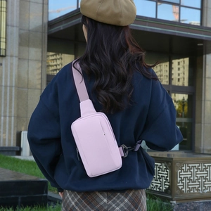 Pale pinkish purple water-resistant crossbody chest bag shown on model in urban setting