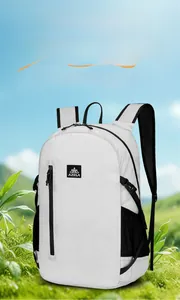 Close-up of lightweight white sports folding backpack with black zippers in nature