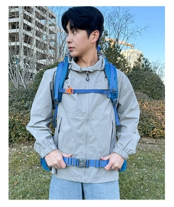 Detail of blue outdoor hiking backpack with padded shoulder straps and grey waist buckle