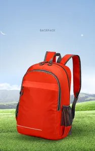 Detail of lightweight orange hiking backpack showing gray mesh pocket and reflective strip