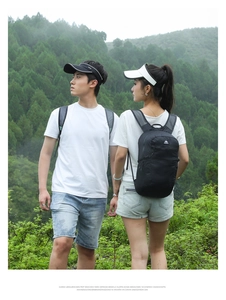 Outdoor setup featuring black lightweight hiking backpack with sun visors and sportswear