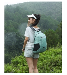 Outdoor light mint green backpack with waterproof fabric shown in a forest setting