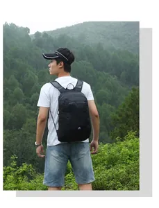 Vista trasera de una mochila deportiva negra en un modelo masculino con fondo de montaña