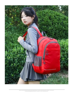 Close-up of a red waterproof sports backpack with gray accents and reflective safety strip