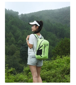 Light green waterproof outdoor backpack shown in a natural hiking environment