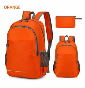Detail of orange lightweight folding backpack showing storage bag and reflective safety strip