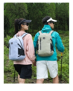 Outdoor hiking backpacks worn by models in a scenic forest with trekking poles