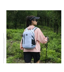 Waterproof light blue hiking backpack featuring side mesh pockets in a mountain setting