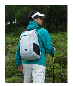 Close-up of lightweight grey outdoor backpack with mesh side pocket on male hiker in forest